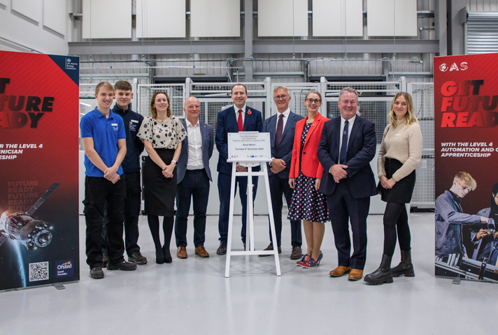 Speakers and apprentices at OAS launch event, standing beside unveiled placard reading "The OAS Extension was opened by Satellite Applications Catapult CEO Stuart Martin, Thursday 9th November 2023".