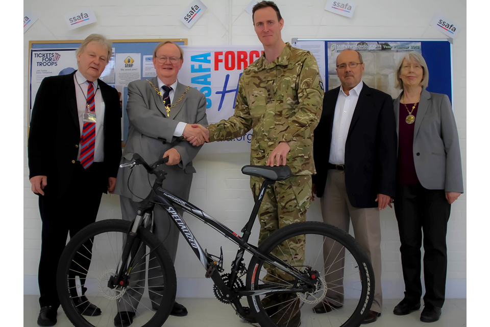 Lieutenant Colonel Oli Stokes receives a bike from the Mayor of the Royal Borough of Greenwich