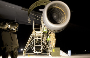 RAF technicians carrying out some late night repairs to an engine on a C-17 aircraft.