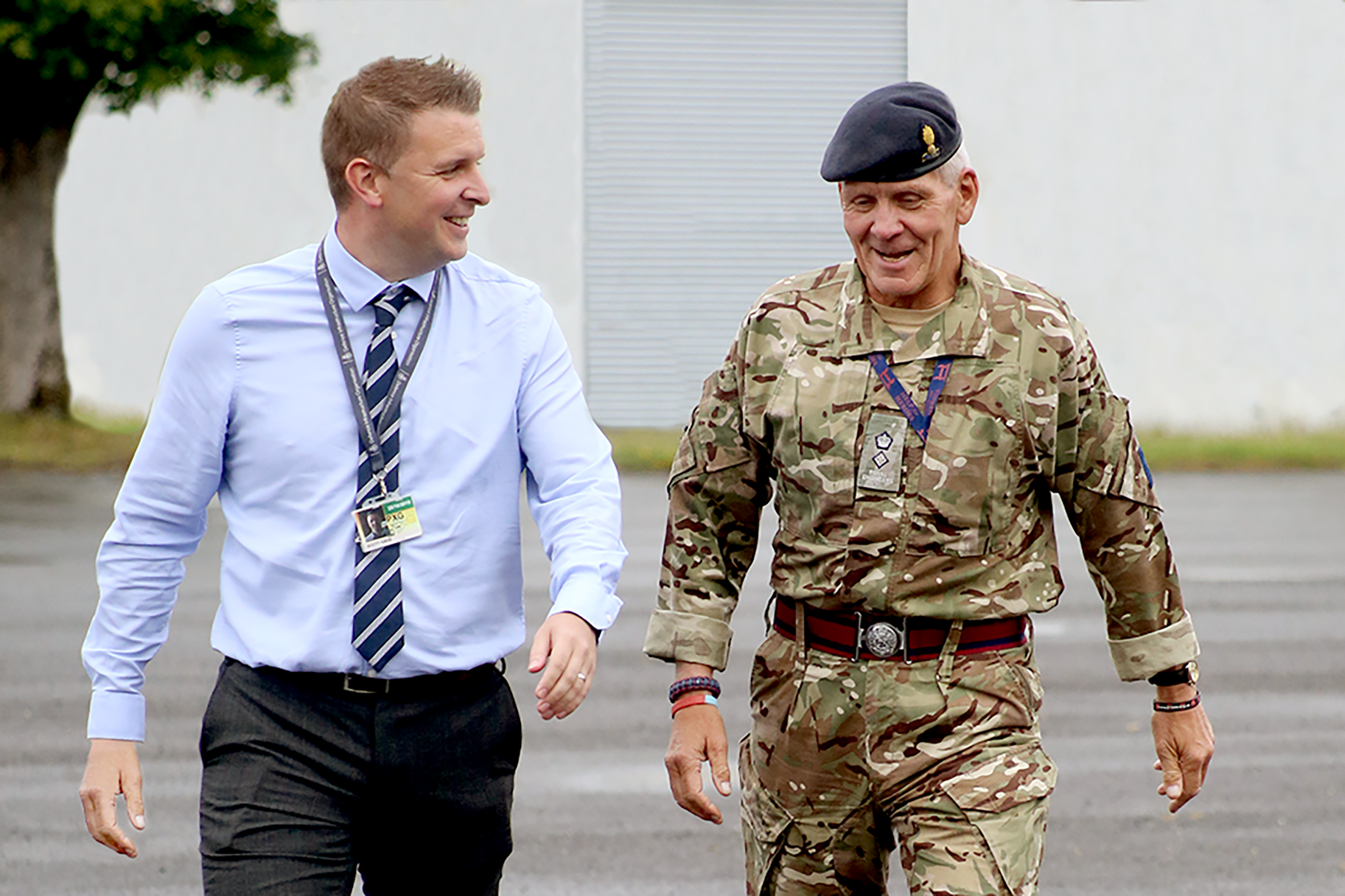 En chef från huvudkontoret promenerar tillsammans med en man i militäruniform.