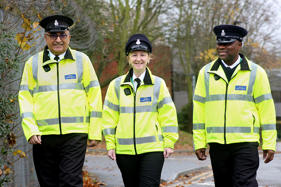 3 MOD-bewakers in hoge zichtbaarheidsjacks tijdens de dienst.