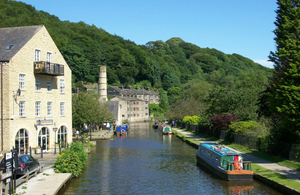 A canal and canal boats alongside some stone buildings