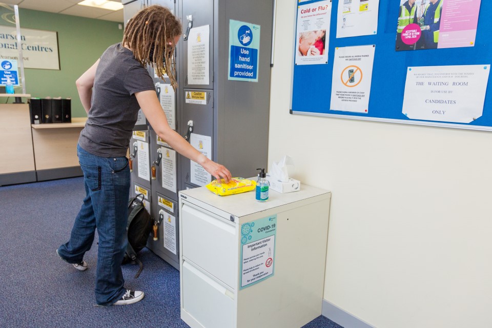 Photo of a woman taking an antiviral wipe from a packet.