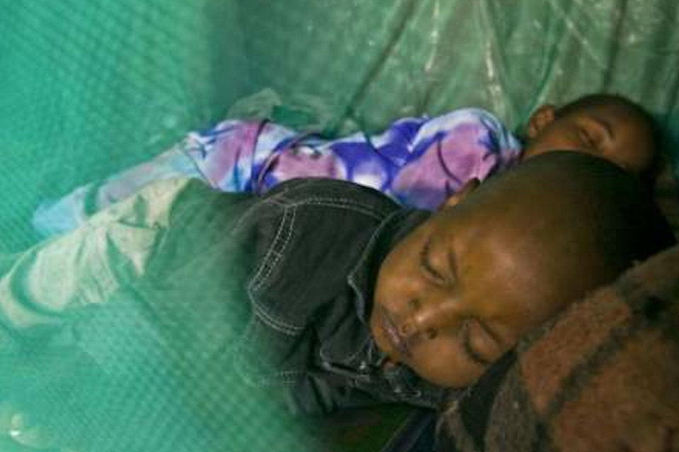 Closeup of Children Sleeping Under Net.