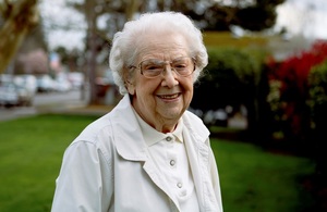 an elderly woman smiling outdoors
