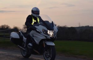 Image shows a motorcyclist riding on a country road