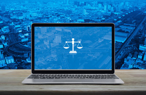 Graphic of laptop showing scales of justice