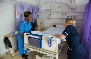 Nurses prepping hospital bed
