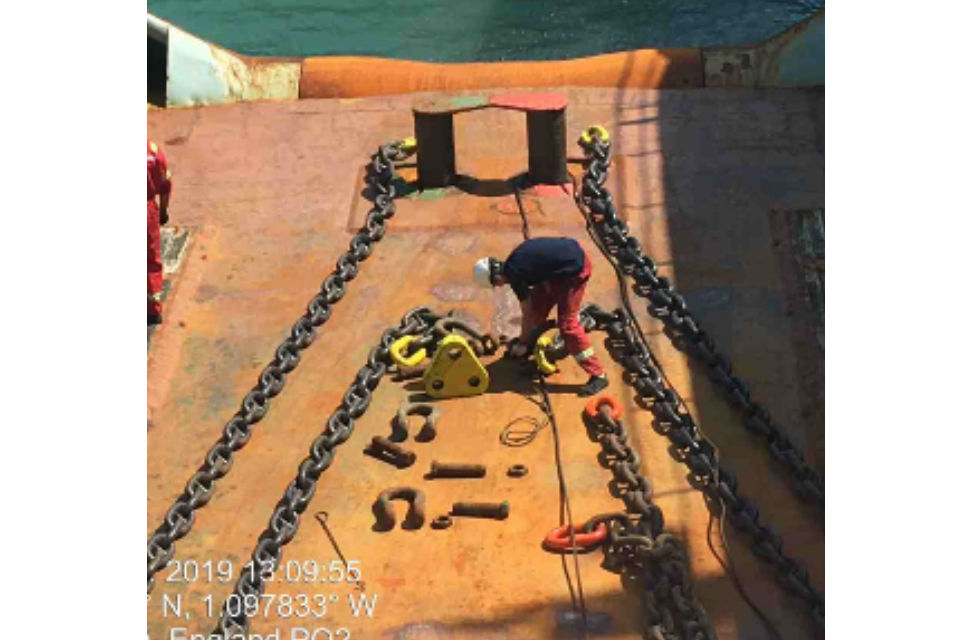Two men prepare the Tugs for towing.
