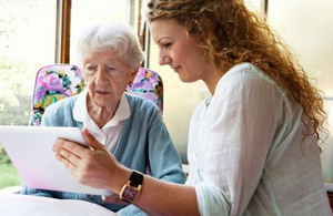 Woman showing older lady a tablet