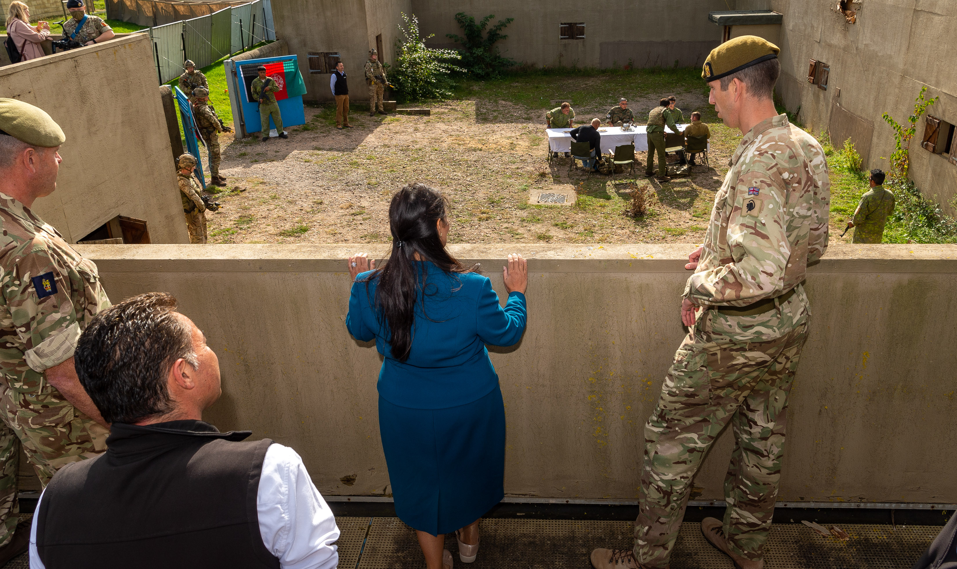 Priti Patel is pictured overlooking interpreter training from a balcony.