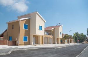 Row of newly built homes on a sunny residential street.