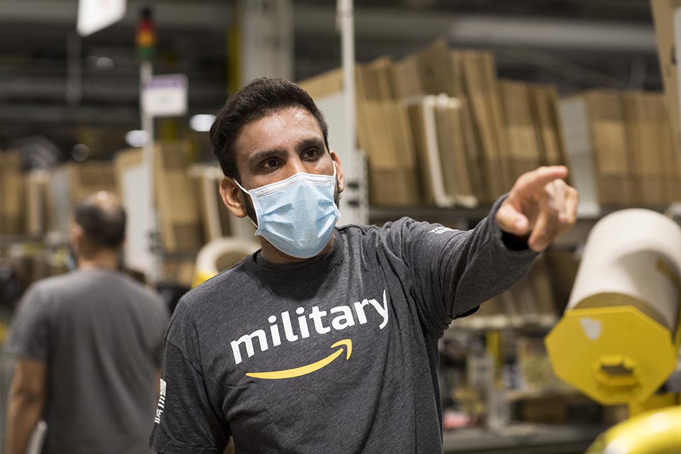 Man wearing a t-shirt with the amazon logo and the word 'military' written across the front.