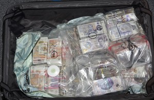 Suitcase showing cash seizure.