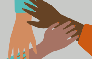 Three hands, of different ethnicities, touching