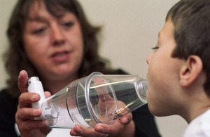 Child being shown how to use volumatic inhaler for asthma