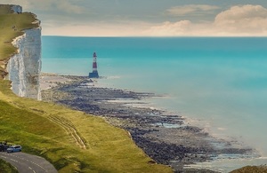 Coastal image with sea, white cliffs and red and white lighthouse