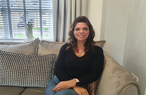 A photograph of Vicky Pike sitting on her sofa.