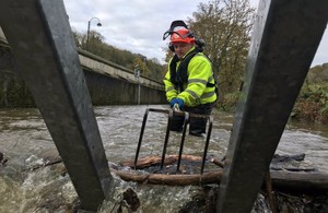 An Environment Agency officer clearing a trash screen