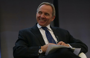 Image depicts a headshot of Sir John Manzoni