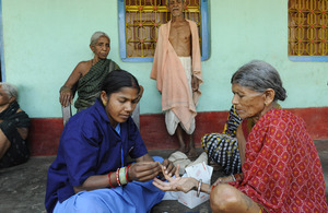 A health worker runs a malaria diagnosis test on an elderly woman. Picture: DFID