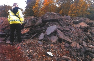 Images show some of the waste illegally deposited on the land, with an Environment Agency officer standing on top of it.