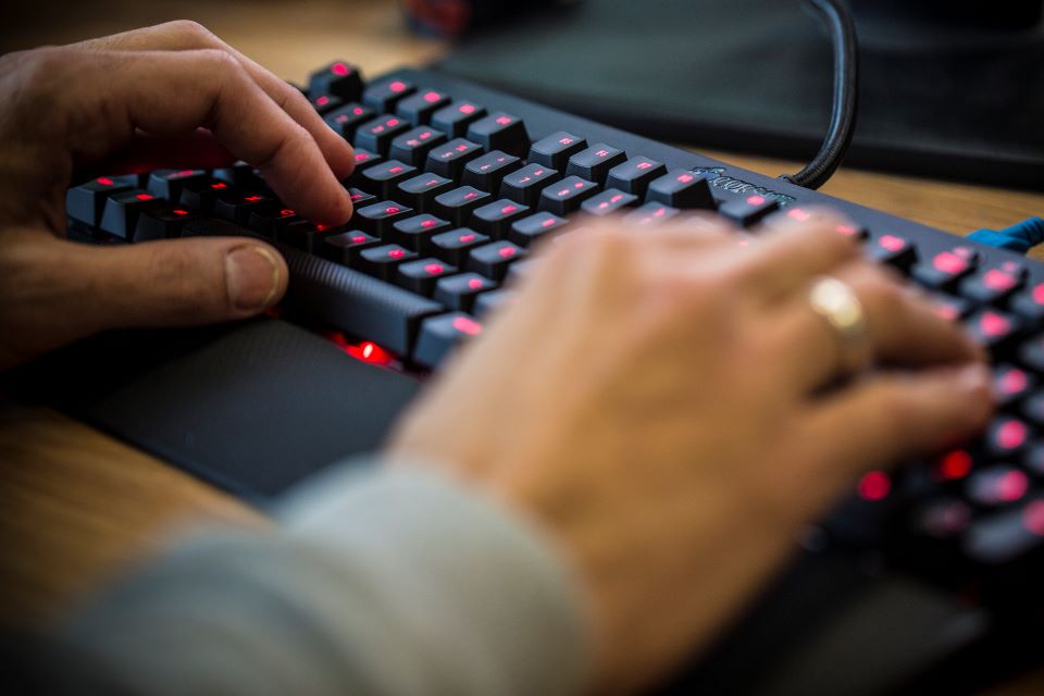 Hands typing on a keyboard.