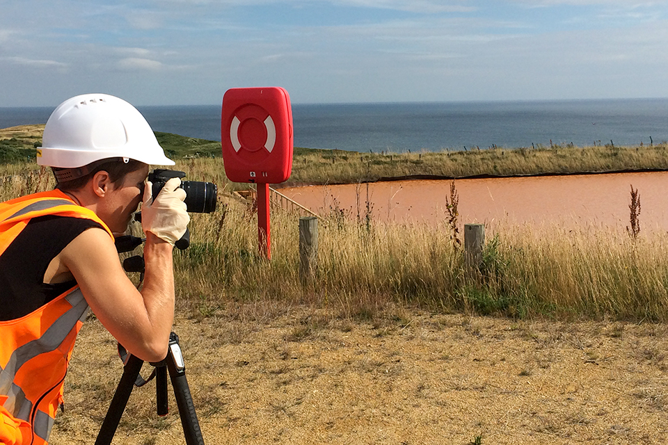 Onya McCausland taking a photograph of a Coal Authority mine water treatment scheme