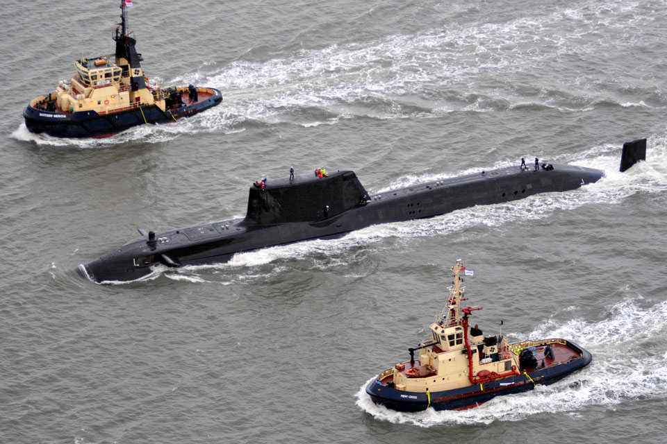 Royal Navy submarine HMS Astute escorted by tugs
