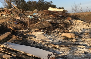 Picture shows large pile of partially burnt rubbish, including mattress springs and a gas bottle