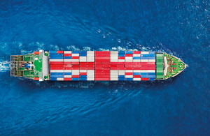 Large ship with shipping containers shaped into the Union Jack