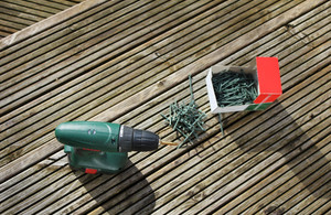 Power drill and screws on wooden decking