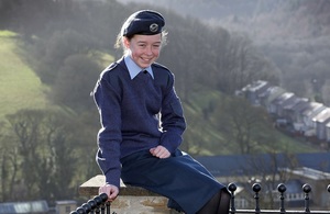 Air Cadet Mya Larder pictured wearing her uniform sitting on a wall smiling directly at the camera.