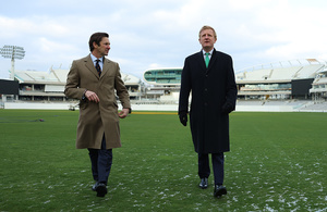 Oliver Dowden and Guy Lavender, Chief Executive of Marylebone Cricket Club (MCC) at Lord's Cricket Ground. They walk towards the camera, two metres apart, outside on a snowy cricket field.