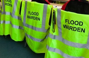 Flood warden hi vis jackets and ppe on backs of chairs in office
