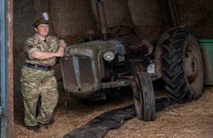 Reservist Tracy Llewellyn standing next to a tractor dressed in full service uniform.