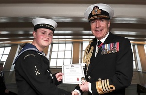 Sea cadet John Challenger being awarded a British Empire Medal (BEM) dressed in full service uniform.