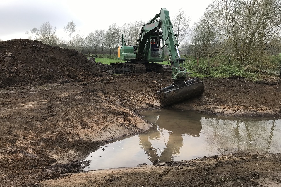 A digger being used to create a backwater.