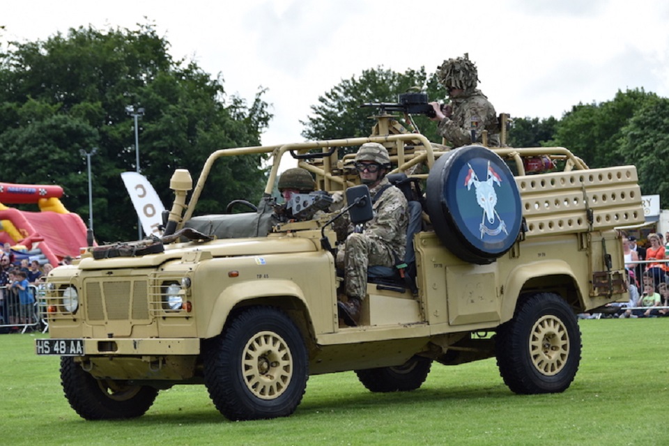 Reservists in uniform driving an army vehicle. 