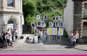 A small community group hold placards saying "It's art but it's not"