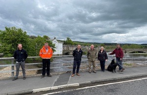 Image shows a line of people standing on the bridge at Haydon Bridge from the Environment Agency, Haydon Bridge Parish Council and contractor Esh.