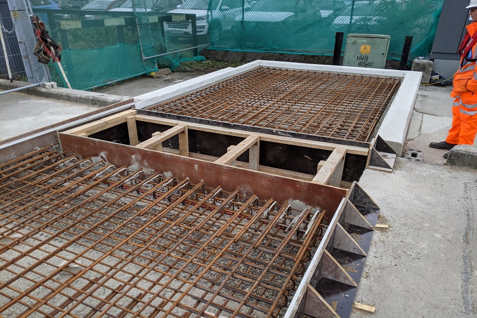 Image shows two large, shallow rectangular boxes containing metal reinforcing grids