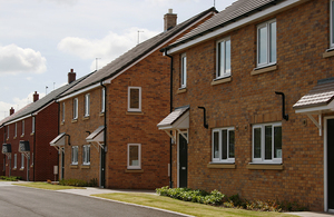 A row of new semi-detached brick houses with small front lawns.