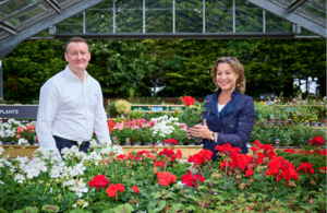 Graeme Jenkins and Rebecca Pow in a greenhouse with some flowering plants