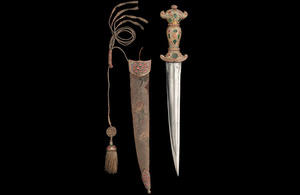 A Mughal Dagger and Scabbard against a black background