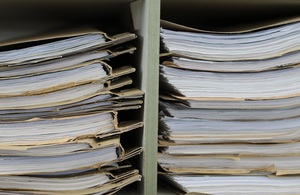Image of papers in cardboard folders stacked in 2 box shelving units
