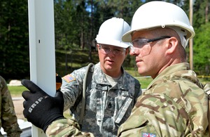 A South Dakota National Guardsman and Sergeant Derran Howe inspect window frames prior to installation [Picture: Corporal Steve Blake RLC, Crown copyright]