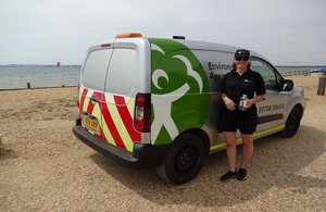 Environment Agency officer sampling water quality at beach.