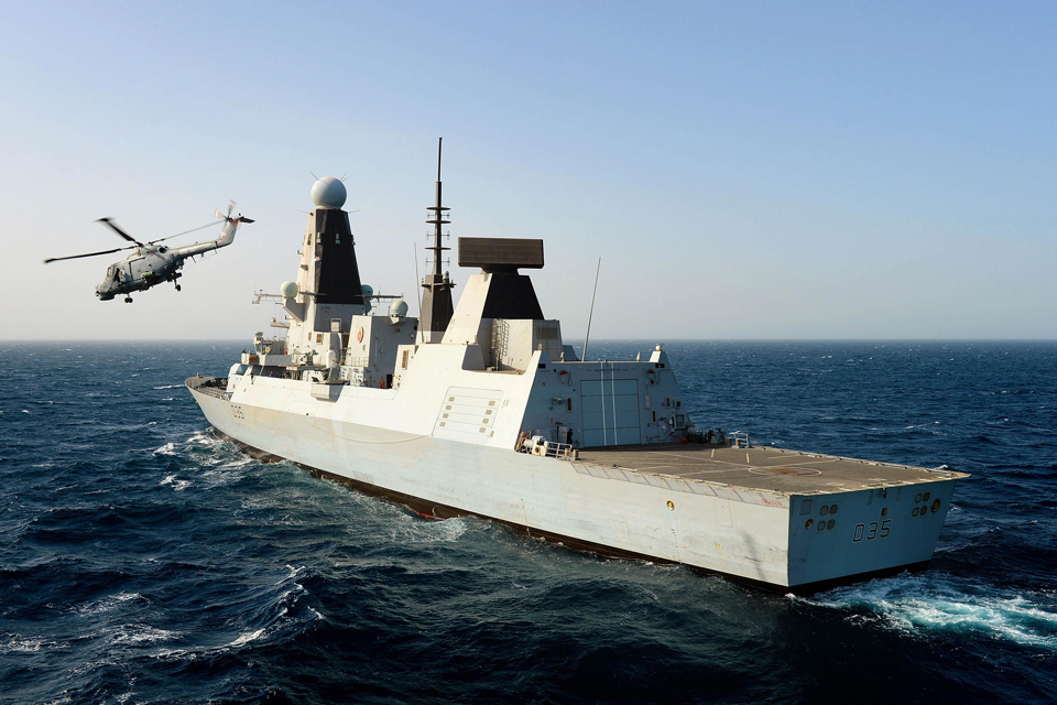 A Lynx helicopter flies from HMS Dragon