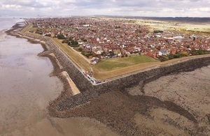 Image shows an aerial view of Canvey Island surrounded by an L shaped barrier of rocks